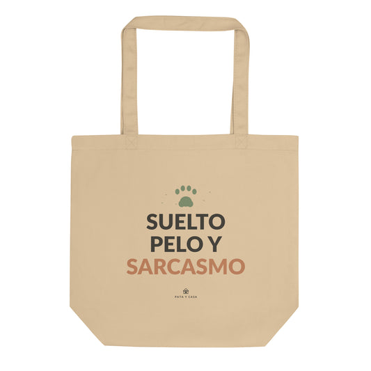 Tote bag color crudo Suelto Pelo y Sarcasmo, vista frontal con estampado negro y terracota