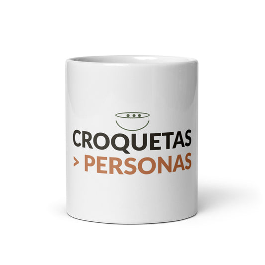 Taza blanca de cerámica con el lema «Croquetas > Personas», vista frontal