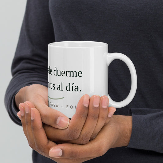 Persona sosteniendo la taza blanca Mi Jefe Duerme 16 Horas con el asa a la derecha